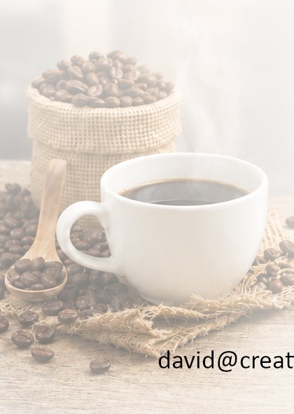 A cup of coffee beside a burlap sack of roasted beans